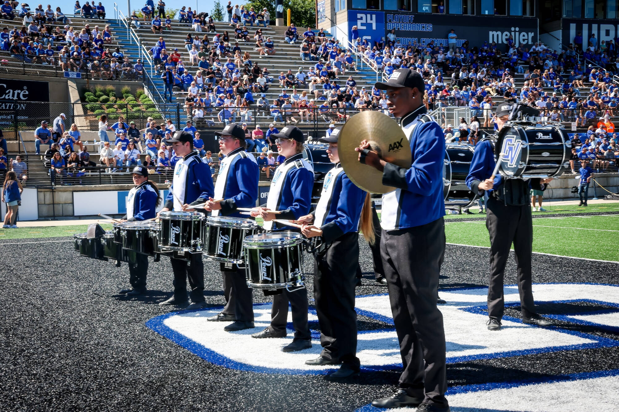 the 2025 LMB drumline standing in the student endzone, facing the student section